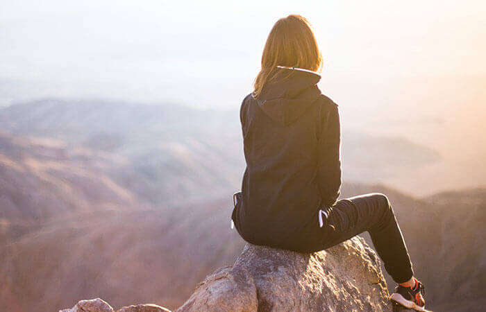 一人寂しく岩の上で佇む女性