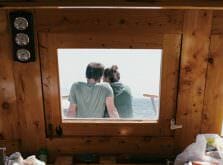 海に浮かぶ船の上で肩を寄せ合うカップル