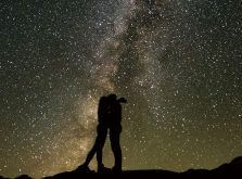 満天の星空の下で抱き合うカップルのシルエット
