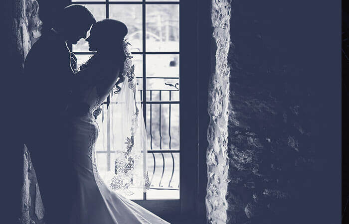 ウェディングドレスとタキシードで抱き合うカップルモノクロ写真