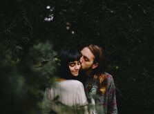林の木陰でキスをするカップル