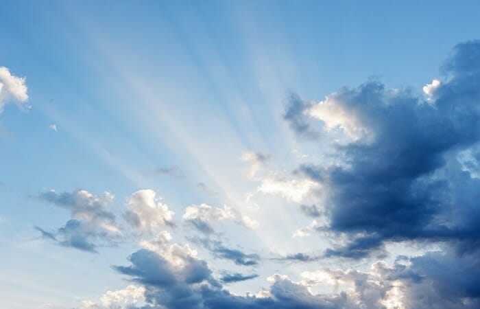 雲が晴れ、雲の隙間から太陽の光が差し込む幻想的な青空