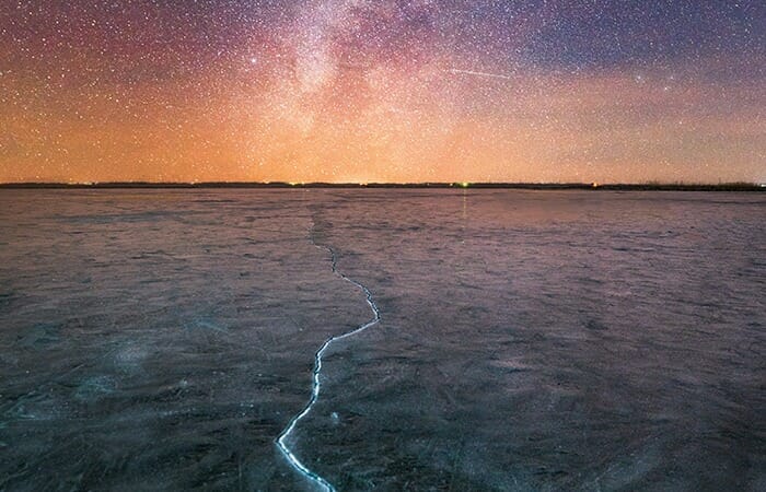 凍りついた地平線の割れ目が神秘的な夜空に向かって伸びる美しい光景