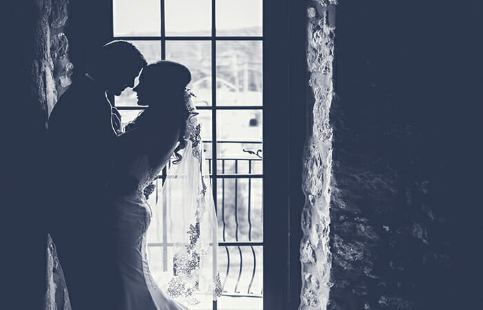 ウェディングドレスとタキシードで抱き合うカップルモノクロ写真